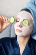 © Parilov - The girl puts and corrects a nutritious mask on a skin with green ripe fresh cucumber. Mask for rejuvenating and eliminating skin defects. Acne