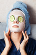 © Parilov - The girl puts and corrects a nutritious mask on a skin with green ripe fresh cucumber. Mask for rejuvenating and eliminating skin defects. Acne