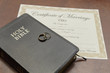 wedding rings with a bible and marriage license 