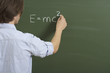 © STOCK4B  - A man is writing a formula on a board