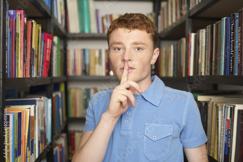 Young Man Making The Sign For No Noise In A Library This Stock Young Man Making The Sign For No Noise In A Library