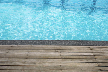 Blue swimming pool summer vacation and wooden deck