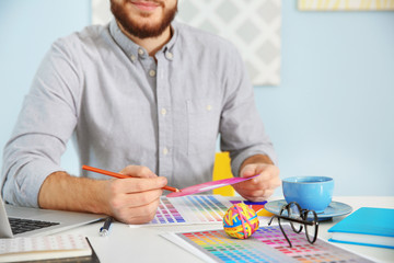 Wall Mural - Young male decorator sitting at desk in office