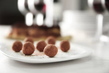 Sticker - Plate with tasty chocolate truffles on white table, closeup