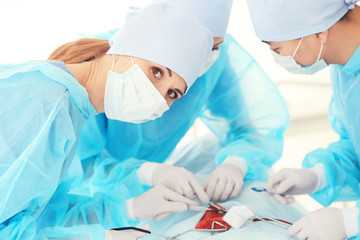 Canvas Print - Young doctors operating patient in clinic