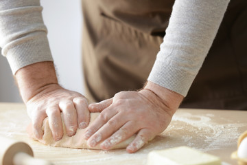 Wall Mural - Hands of man making dough in kitchen