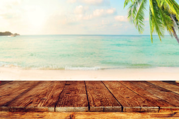 Wall Mural - top of wood table on blurred sea with coconut tree background - empty ready for your product display