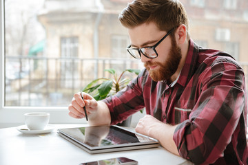 Sticker - Amazing bearded young man using tablet computer.