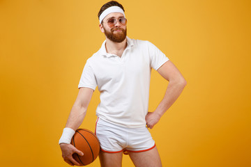 Wall Mural - Sportsman in sunglasses holding basketball