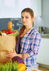 Wall Mural - Young woman holding grocery shopping bag with vegetables