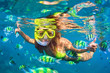 Happy family - girl in snorkeling mask dive underwater with fishes school in coral reef sea pool. Travel lifestyle, water sport outdoor adventure, swimming lessons on summer beach holidays with child.