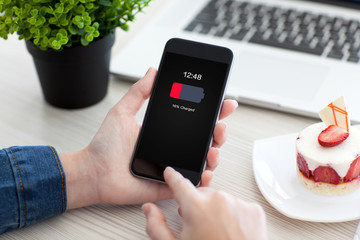 Women hands holding phone with low charged battery screen