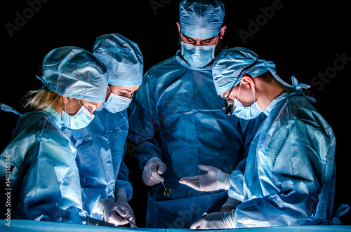 Cuadros en Lienzo The assistant submits the instrument to the doctor during the operation