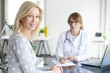 © sepy - Doctor and her patient. Shot of a middle aged smiling female doctor sitting in front of laptop and meeting with her patient.