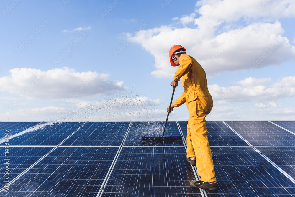 Worker cleaning solar panels