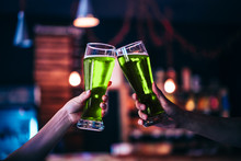 Two Friends Toasting With Glasses Of Green Beer At The Pub With Free Space For Your Text. Beautiful Background Of The Oktoberfest And St. Patrick's Day. Fine Grain. Soft Focus. Shallow DOF