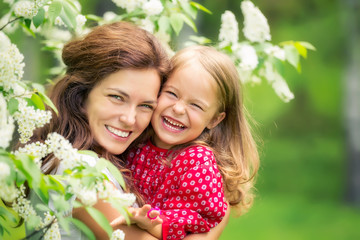 Portrait of happy mother and little daughter in spring park