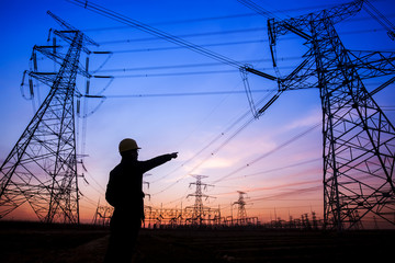 Electricity workers and pylon silhouette