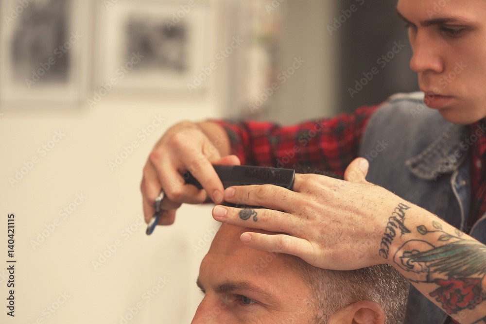 Barber making modern male hairstyle