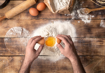 Poster - Male hands beat the egg yolk into the flour