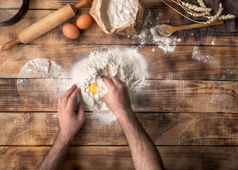 Poster - Man cooking bread dough on wooden table in bakery