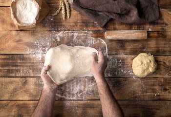 Poster - Male hand preparing pizza dough on the wooden table