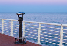Coin Operated Binoculars On A Pier Overlooking The Sea