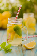 Wall Mural - lemonade with mint on rocks served in jar with a straw