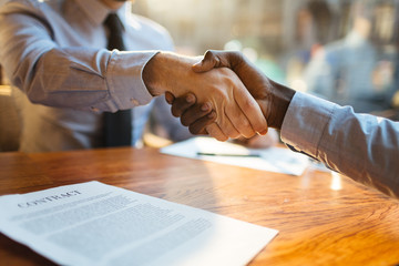 Sticker - Two human hands in handshake over business contract