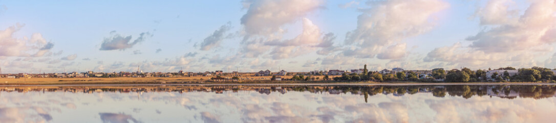 Wall Mural - panoramic view of small town or village overlooks to lake or river at dawnm reflecting in water surf