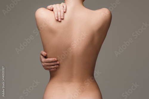 Cuadros en Lienzo The beautiful woman's body on gray background
