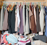 Fototapeta Paryż - Pile of messy clothes in closet. Untidy cluttered woman wardrobe.