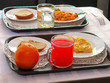 Апельсин и стеклянная кружка с соком на подносе с завтраками