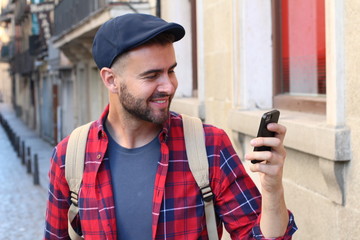 Stylish man looking at phone in the city 