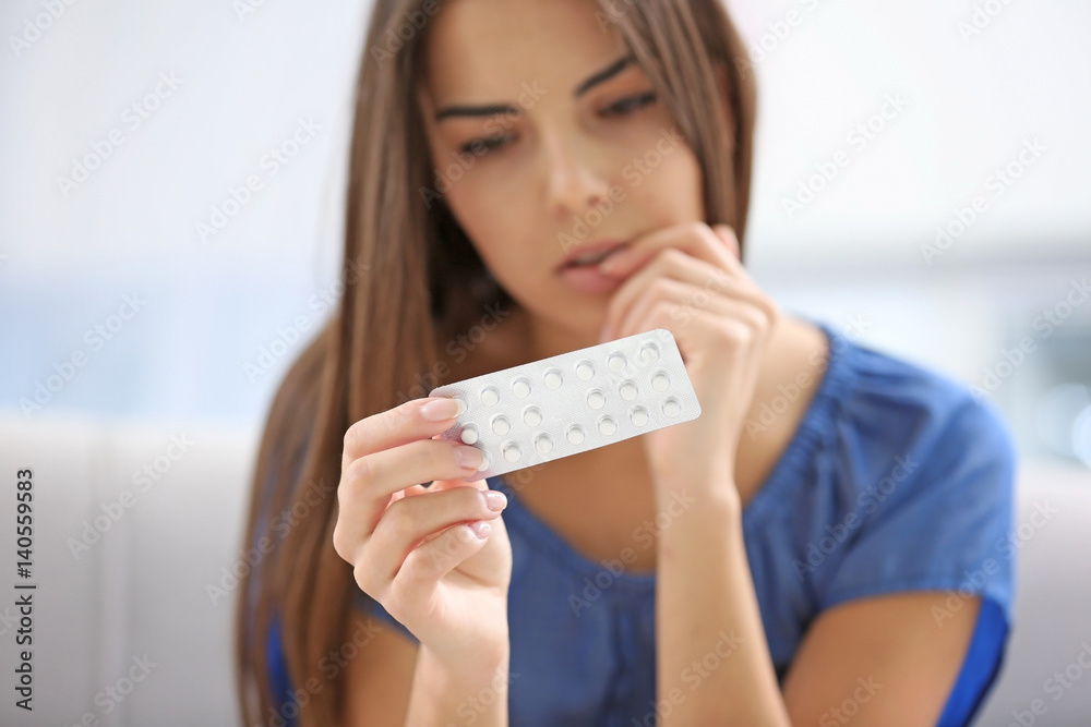 Young woman with pills at home, closeup. Gynecology concept - obrazy, fototapety, plakaty 