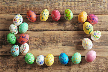 Wall Mural - Colourful Easter eggs with floral ornament on wooden background