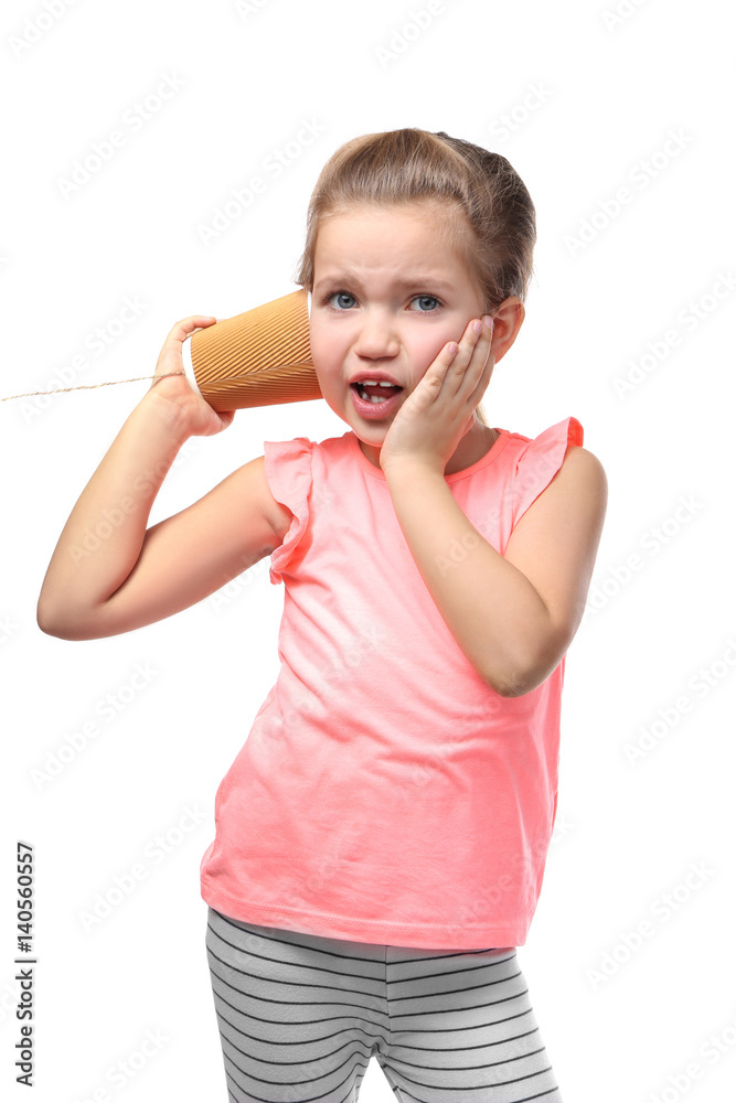 Cute little girl using plastic cup as telephone, on white background
