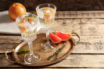 Sticker - Tray with refreshing cocktails and grapefruit on wooden table