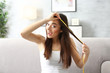 © Africa Studio - Young woman measuring hair length at home