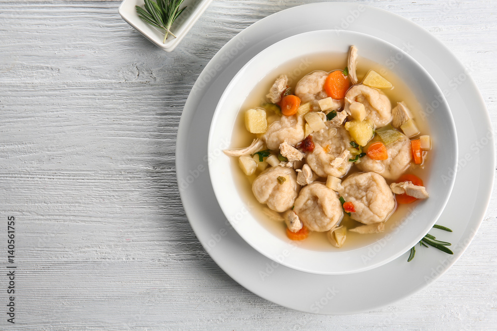 White plate with delicious chicken and dumplings on light background