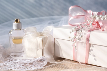 Wall Mural - Wonderful composition of gift boxes, perfume and bridal veil on light background