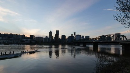 Wall Mural - 4k time lapse video of moving clouds and sky over downtown city skyline and people kayaking in Portland Oregon with water reflection from sunset into blue hour UHD 4096x2304