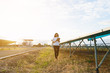 © only_kim - woman engineer working on checking checking status equipment at solar power plant with tablet checklist; woman working on outdoor at solar power plant