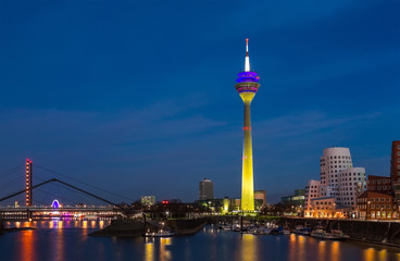 Wall Mural - Colorful night scene of Rhein river at night in Dusseldorf. Rheinturm tower in the soft night light, Nordrhein-Westfalen, Germany, Europe.