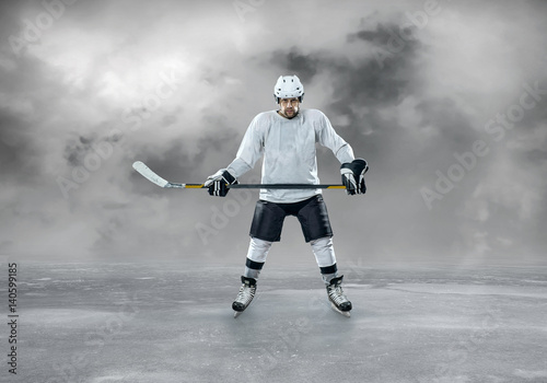 Fototapeta na szkło Ice hockey player in action outdoor around mountains