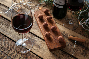 Wall Mural - Red wine, chocolate dessert and Christmas decorations on wooden table