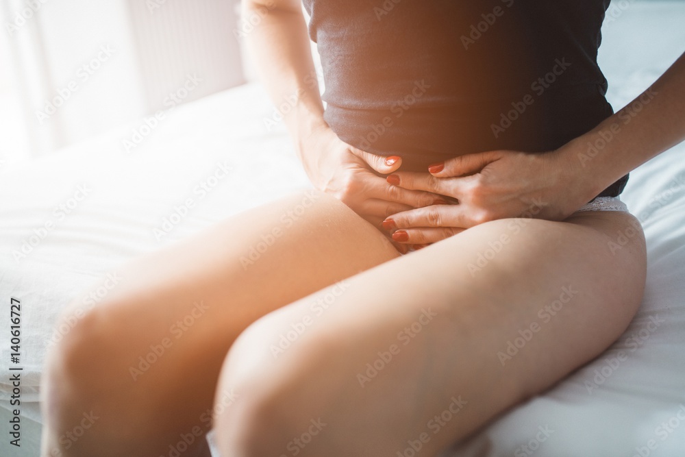 Woman suffers from menstruation pain or stomach ache - obrazy, fototapety, plakaty 