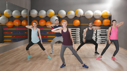 Canvas Print - Young sporty people training in gym