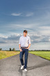 © MDBPIXS - Full length of young man walking on empty rural road