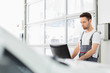 © moodboard - Young male automobile mechanic using computer in repair shop